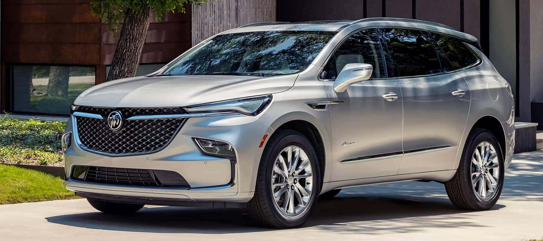 Silver SUV with sleek design parked on a driveway, showcasing luxury automotive features.