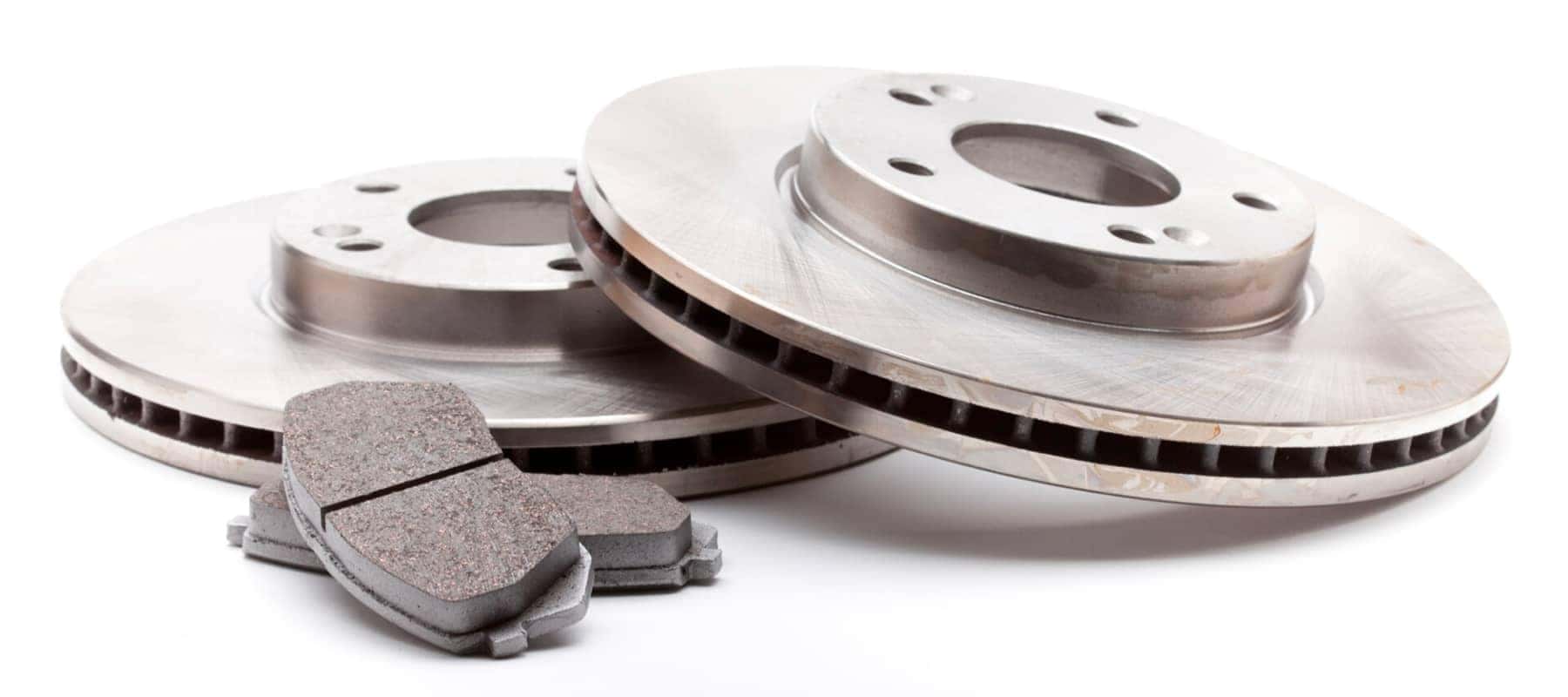 Close-up of car brake discs and pads on a white background.