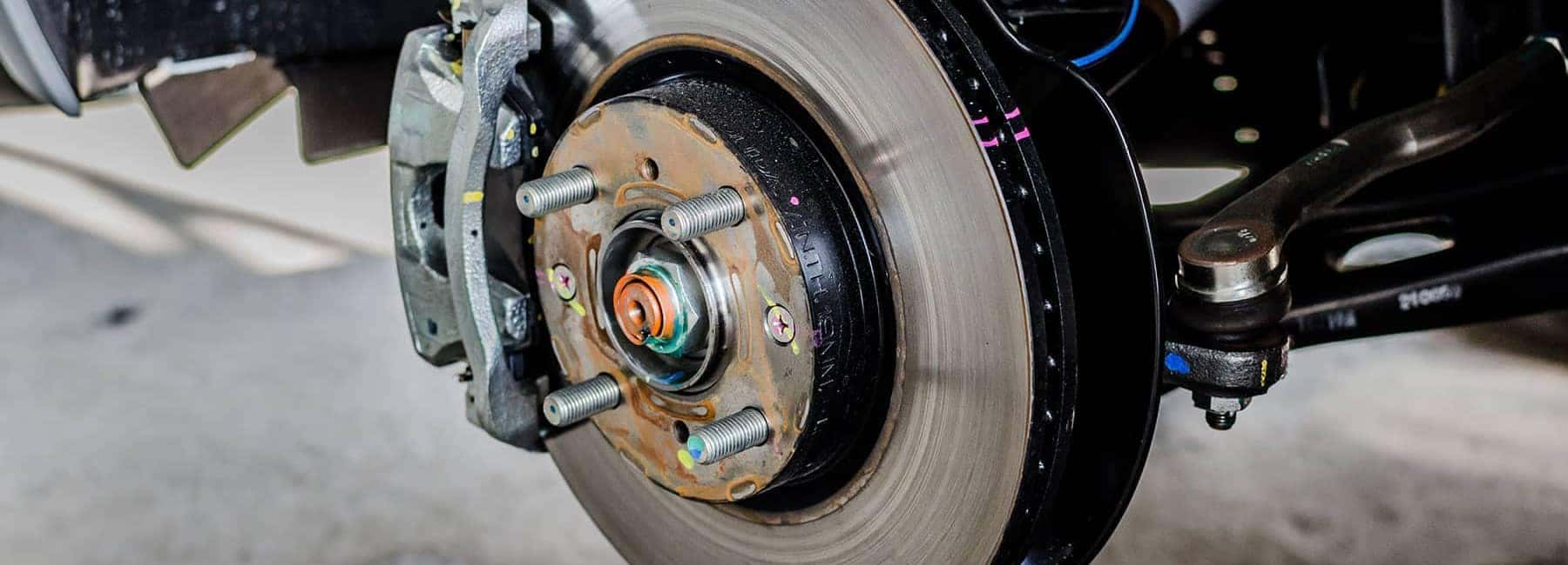 Close-up of a car brake rotor and caliper, showcasing detailed automotive components.