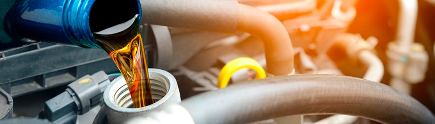 Motor oil being poured into a car engine, highlighting vehicle maintenance.