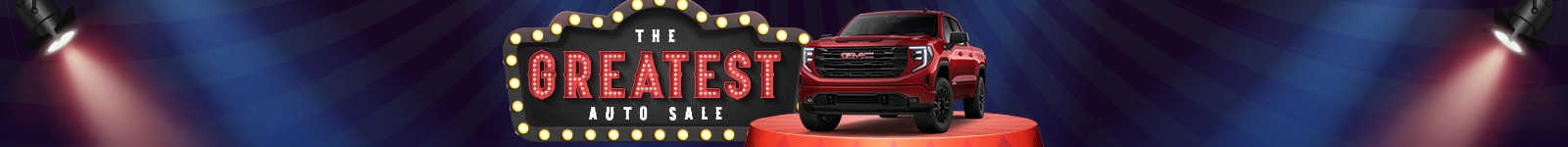 Red SUV on stage under spotlights with a marquee sign reading "The Greatest Auto Sale."