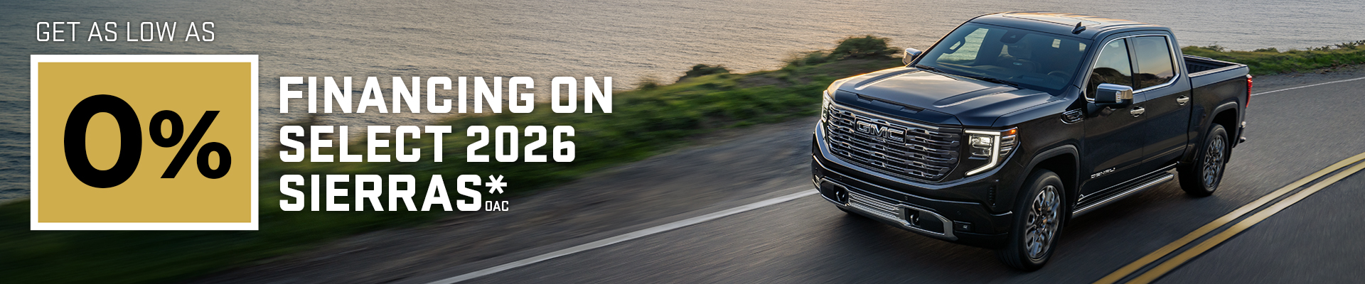 0% financing offer on 2026 GMC Sierra truck driving on a scenic coastal road.