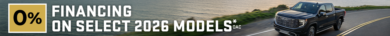 0% financing on select 2026 models. Black pickup truck driving on coastal road.